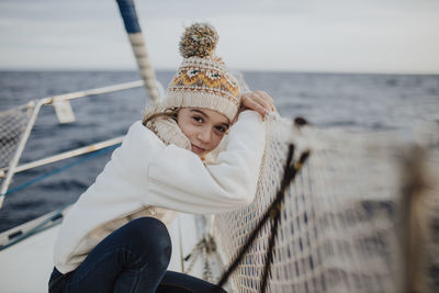 Portrait of woman wearing hat against sea against sky