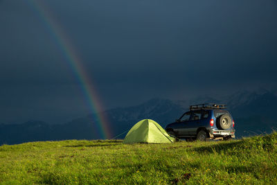 Travel to the mountains by car with a tent. rainbow after rain