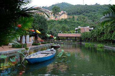 Boats moored in lake by building