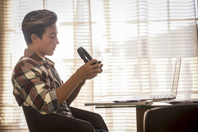 Side view of boy sitting on table