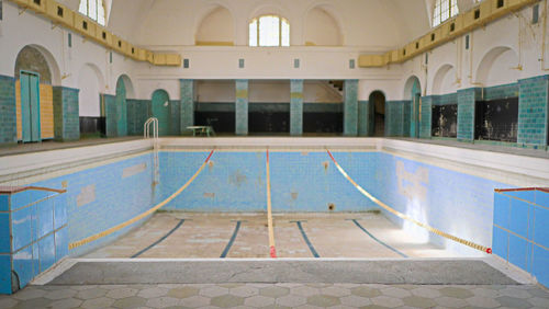 Empty swimming pool by building