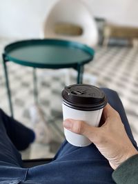 Close-up of hand holding coffee cup