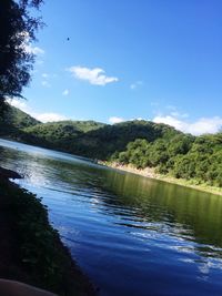 Scenic view of lake in forest against blue sky