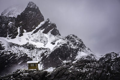 A little shed in front of jade dragon snow mountain peak,snowcapped mountain agains tge sky