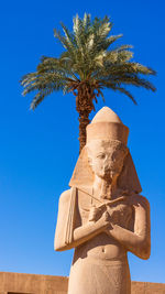 Low angle view of statue against clear blue sky