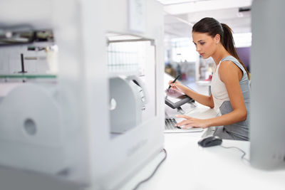 Side view of young woman working at home