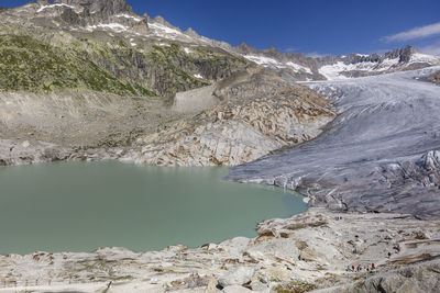 Scenic view of lake by snowcapped mountain against sky