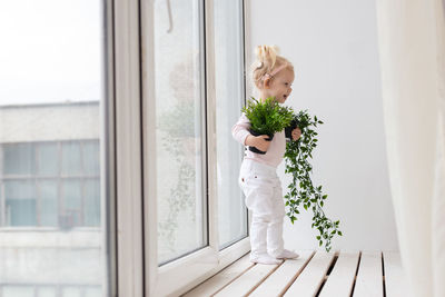 Midsection of woman standing by window