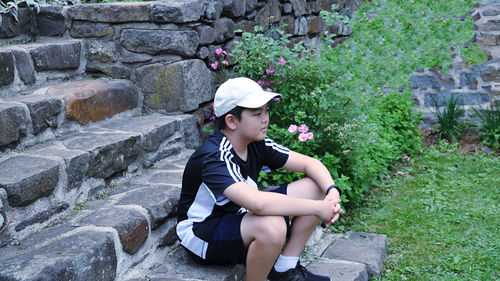 Full length of woman sitting against wall