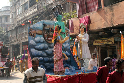 Male and female sculptures on cart at street during festival