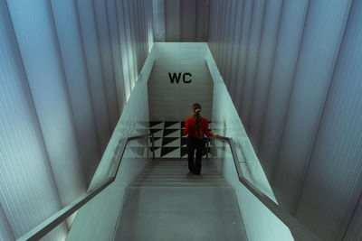 Rear view of woman walking on steps at subway station