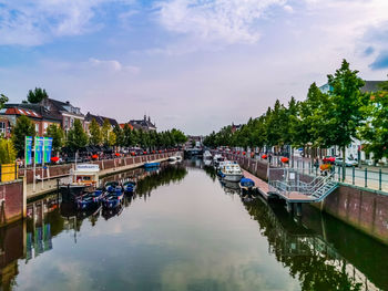 Panoramic view of canal in city against sky