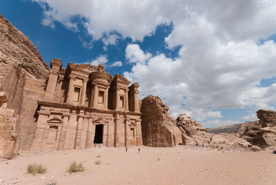 The monastery at petra in jordan against a blue sky with clouds