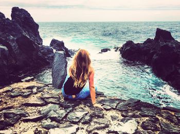 Rear view of woman looking at sea against sky