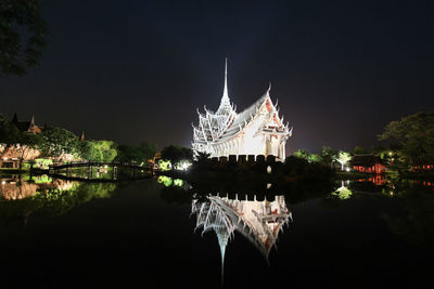 Illuminated building against sky at night