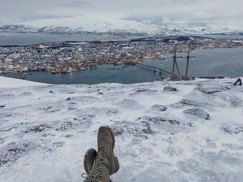 Low section of person against cityscape during winter