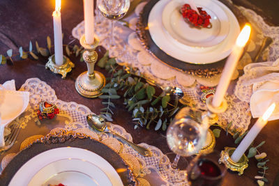 High angle view of candles by plate on table