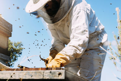 Low angle view of man working against sky