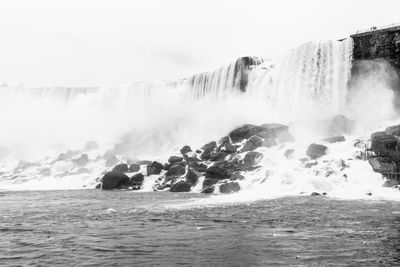 Scenic view of waterfall against sea