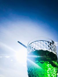 Close-up of glass of water against blue sky