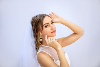 Portrait of beautiful young woman against white background