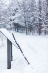 Snow covered land and trees on field