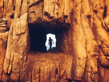 Low angle view of man standing in cave