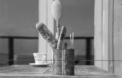 Spoons in container on wooden table