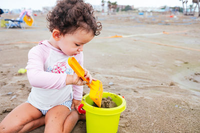 Cute girl playing with toy on beach