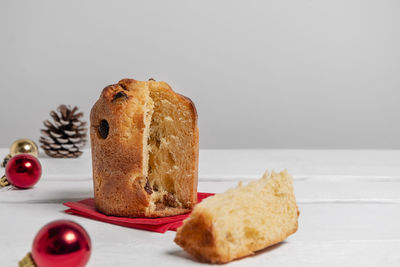 Italian dessert mini panettone surrounded by christmas decorations on white background