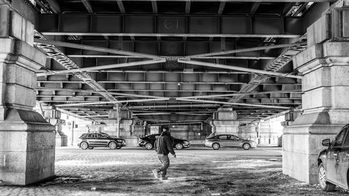 Full length of man walking below bridge