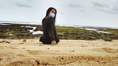 Woman on beach against sky