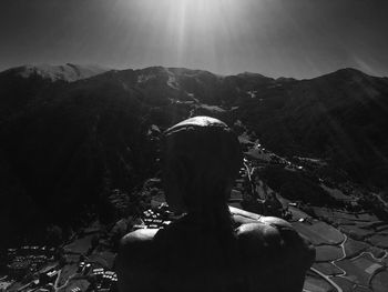 Rear view of woman looking at mountains against sky
