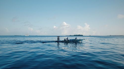 People enjoying in sea against sky