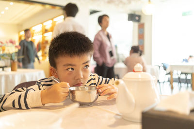 Portrait of boy with ice cream in restaurant