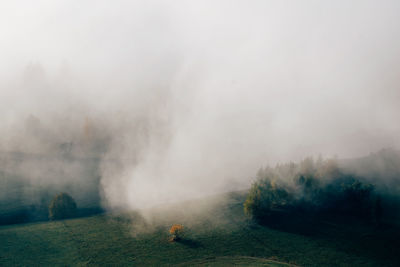 Scenic view of landscape during foggy weather against sky