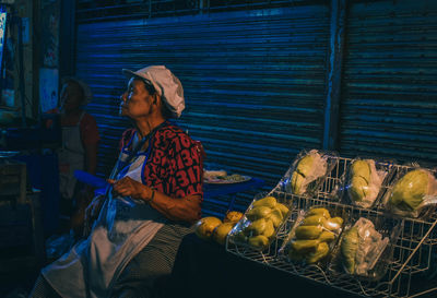 Woman with vegetables for sale at market stall