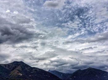 Scenic view of mountains against cloudy sky