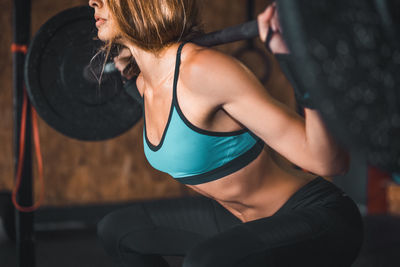 Midsection of young woman with arms raised