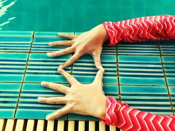 Cropped hands of woman making finger frame at poolside