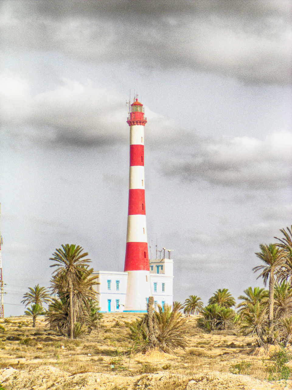 LIGHTHOUSE AGAINST SKY AND TREES AND BUILDINGS