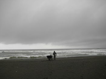 Man standing on beach against sky