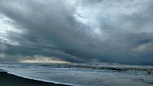 Scenic view of sea against storm clouds