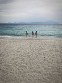 People at beach against sky