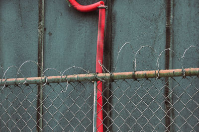Close-up of chainlink fence against wall