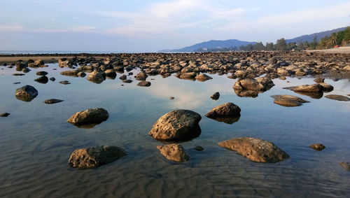 Rocks in sea against sky