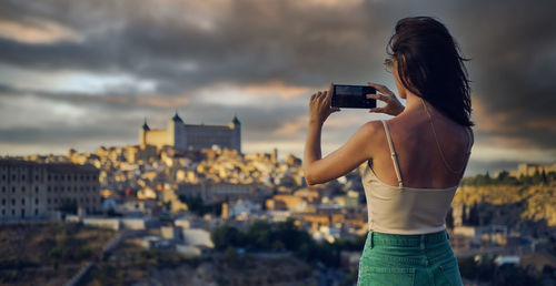 Rear view of woman photographing with camera