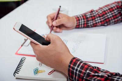 Midsection of woman reading book on table