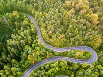 Winding road from high mountain pass, in summer time. aerial view by drone. romania
