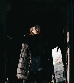 Fashionable woman standing at doorway looking away